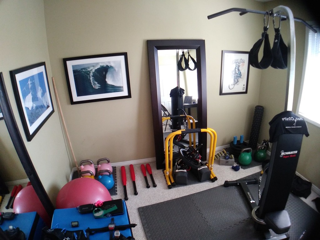 Ett välutrustat hemmagym i ett garage med en power rack, skivstång, vikter och en träningsbänk.